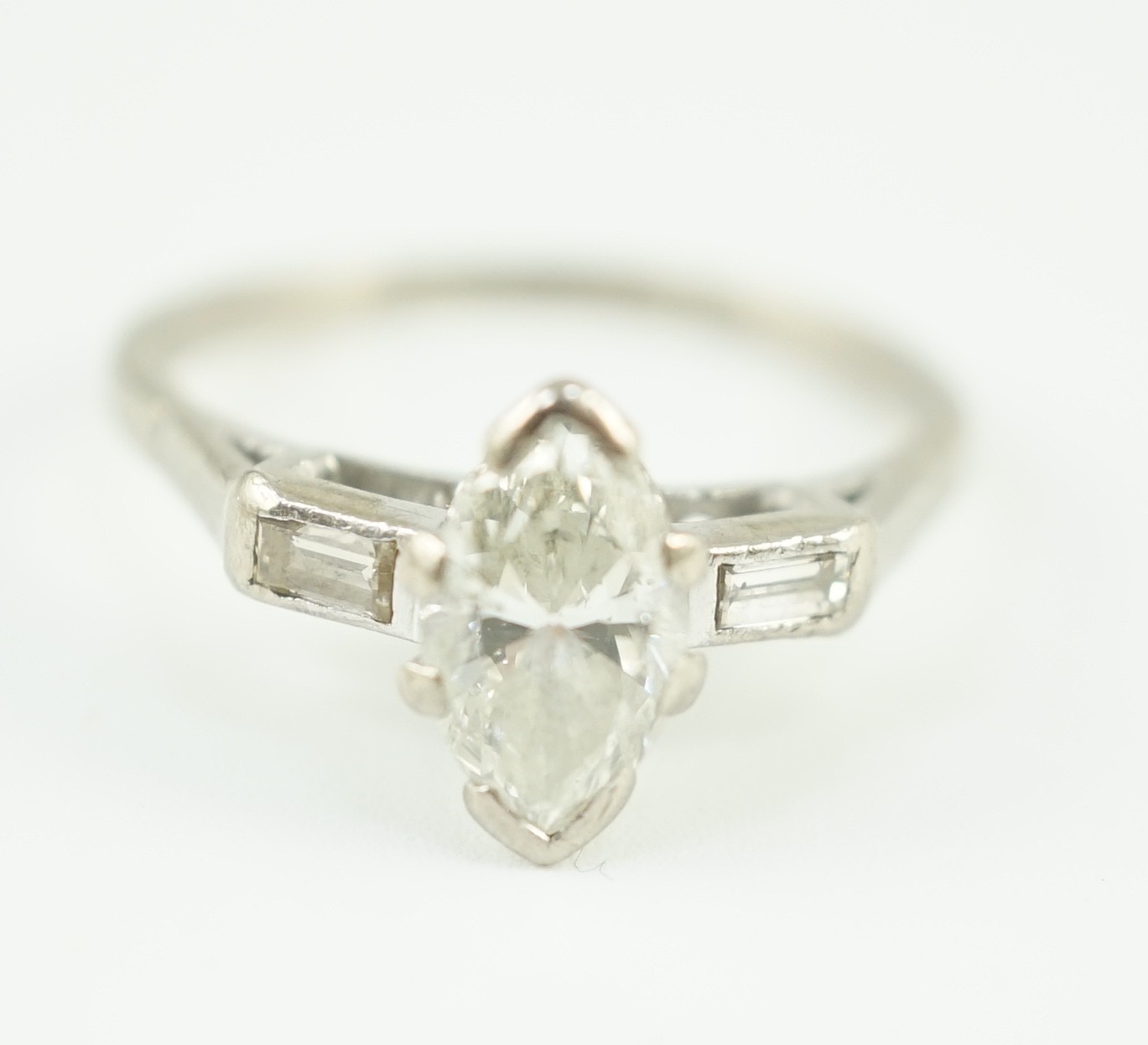 An 18ct white gold and single stone marquise cut diamond set ring, with baguette cut diamond set shoulders